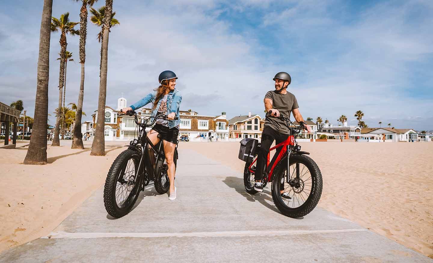 Woman and man riding with Juiced electric bikes on the beach