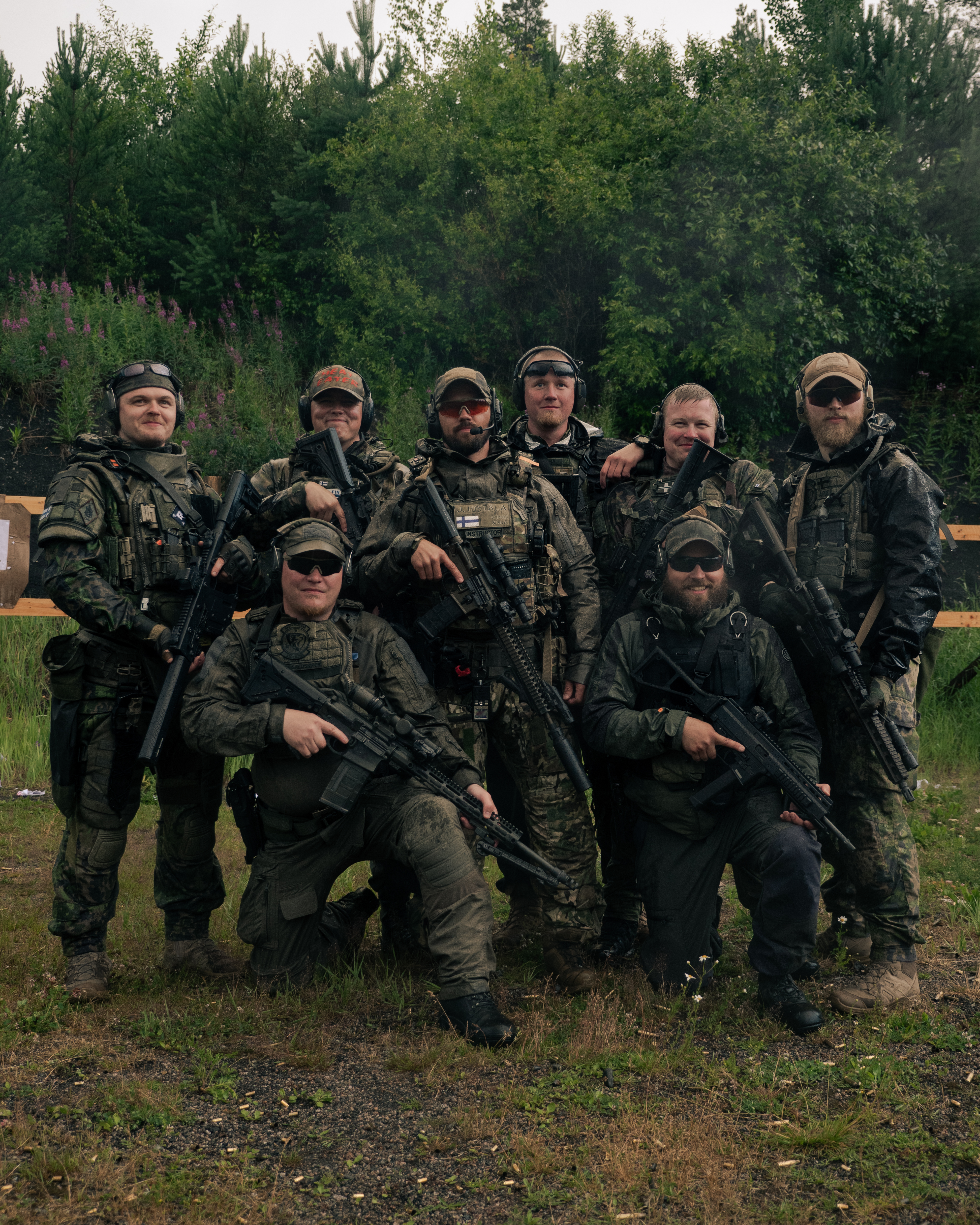 Group picture of finnish reservist. Jere Hietala is in the middle. The men have rifles in there hands. They are on a shooting range. They are wearing tactical clothing. Some of them are wearing M05 camo.