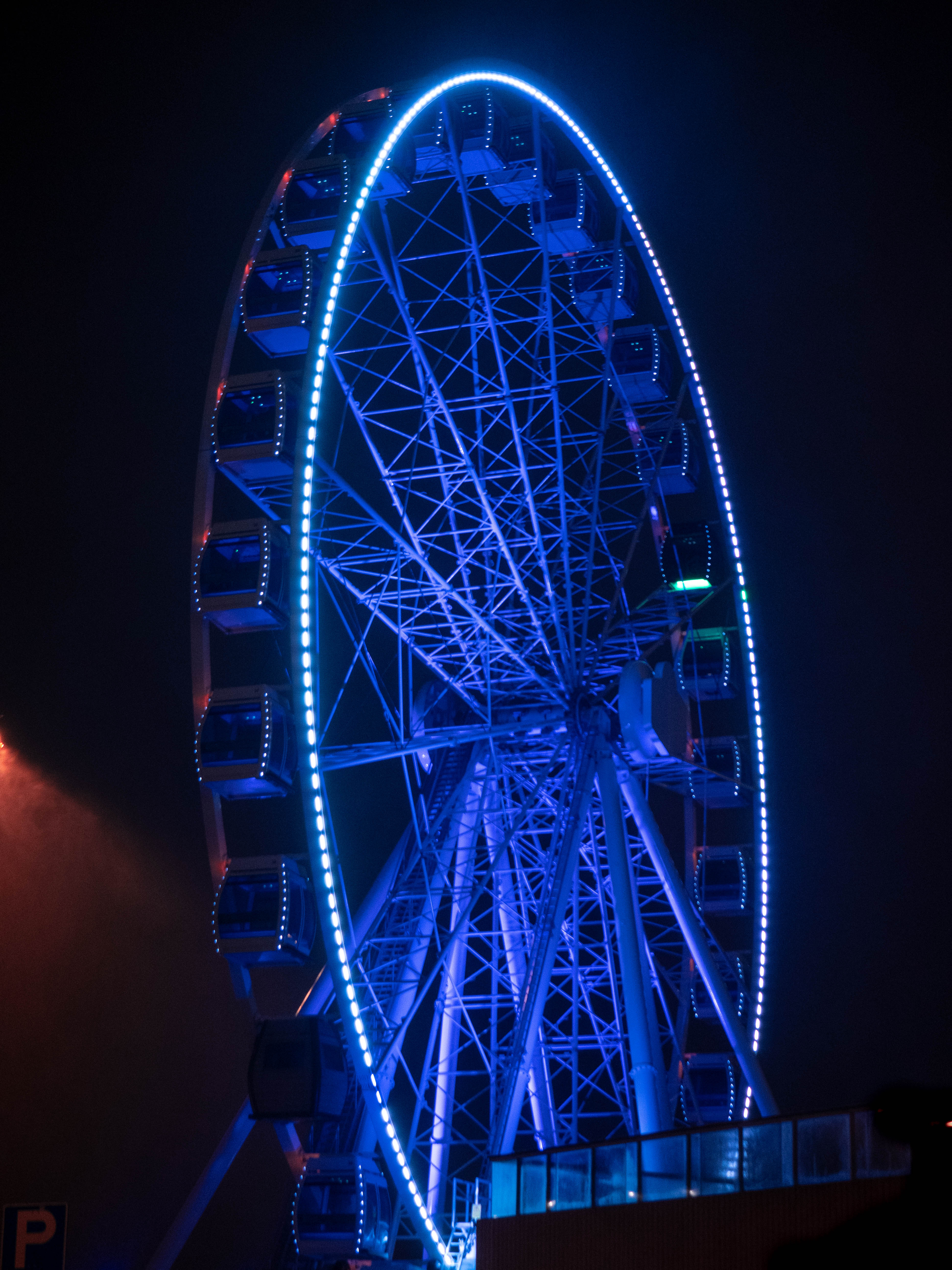 Eye of Helsinki carousel. Located on Katajanokka in Helsinki. At night. Blue led lights. Haze and fog.