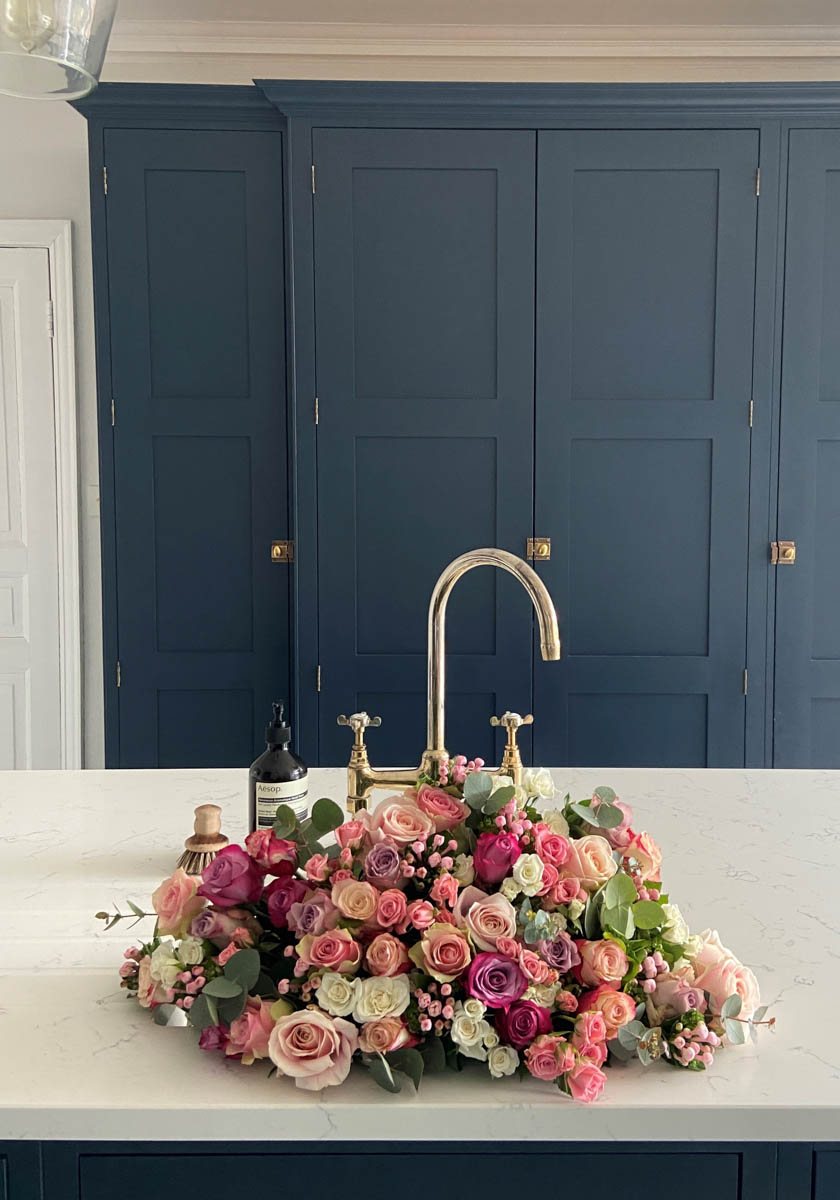 Dark blue kitchen cabinetry painted with Bond Street No.219, behind a bouquet of flowers

