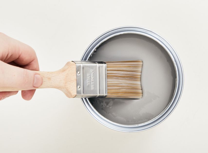 A tin of graphite coloured paint Leadenhall No.118, with a brush dipped in it

