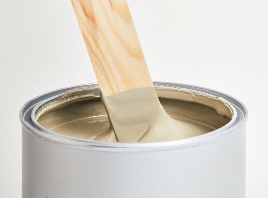 A tin filled with dusty grey paint Portcullis No.170, with a stirrer dipped in it