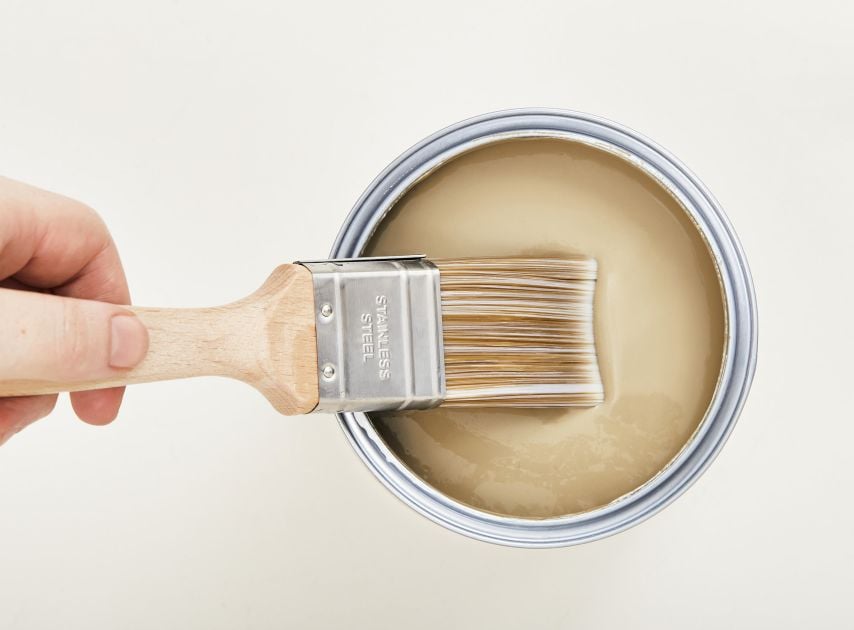 A tin filled with warm natural Brown paint Westmoreland No.160 , with a brush dipped in it

