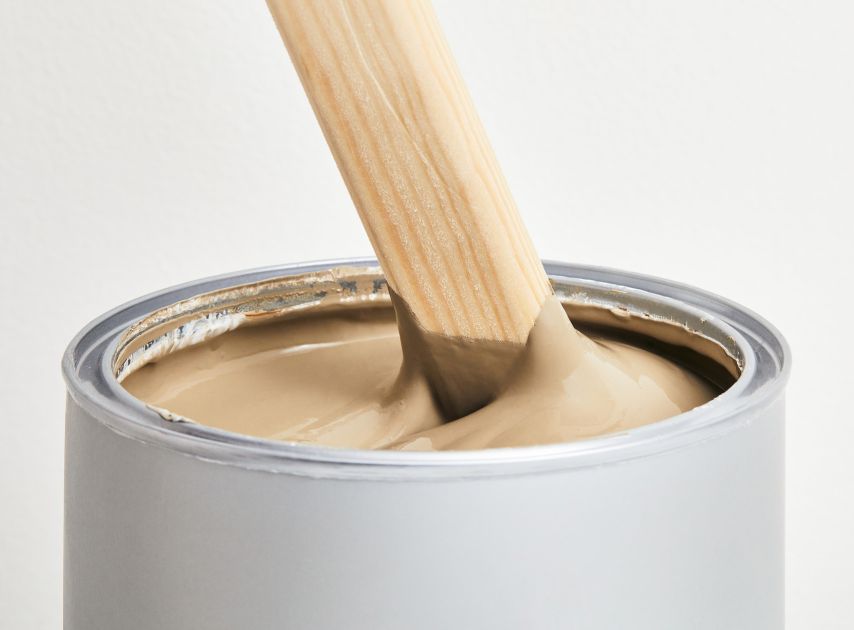 A tin filled with warm natural Brown paint Westmoreland No.160 , with a stirrer dipped in it

