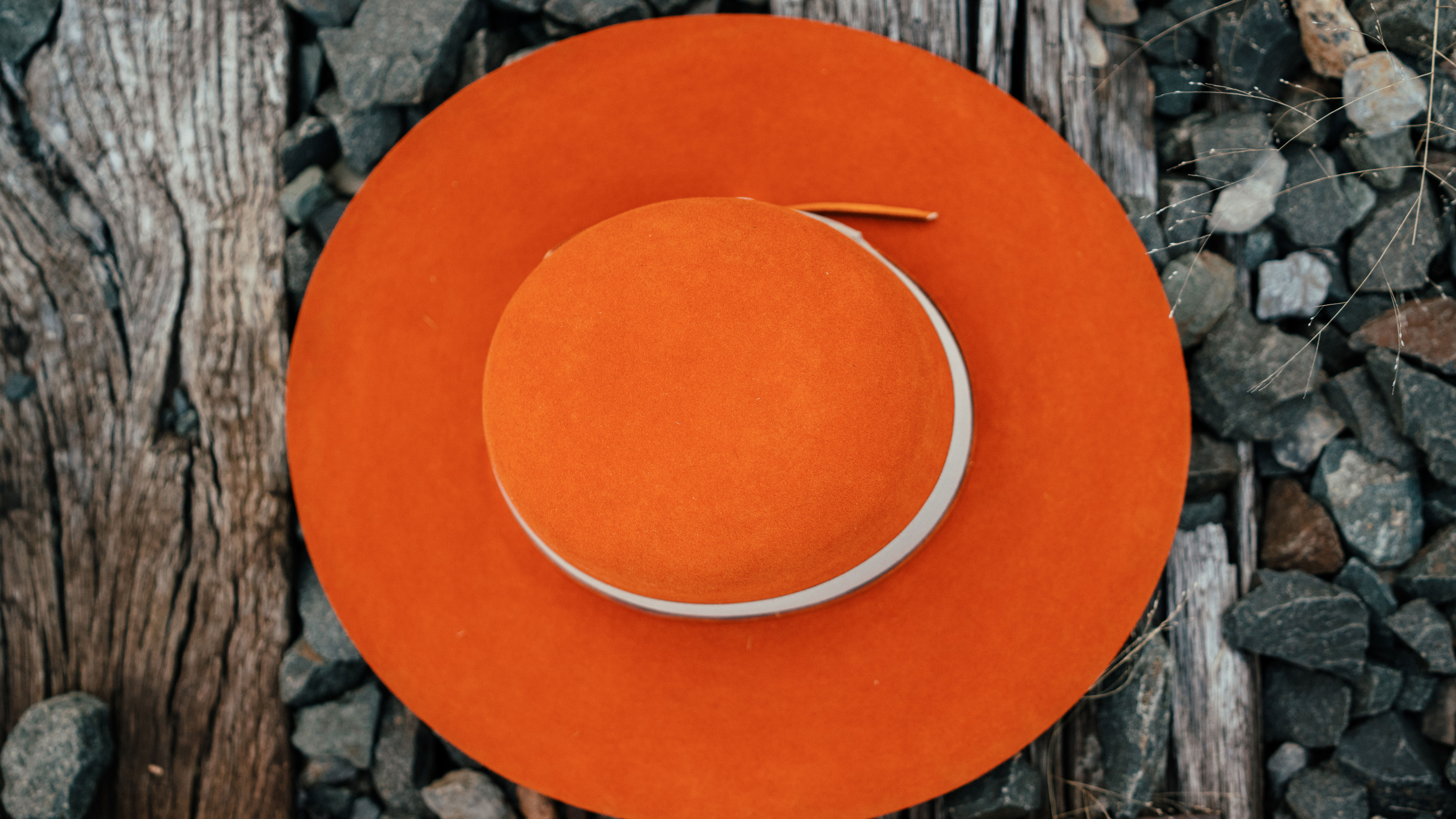 Design
100% Light Weight Dressed Beaver Fur Felt. A Vibrant atomic tangerine color adorned with a thin Italian cognac leather band. A subtle but distinctive mother-of-pearl button dots the band and draws the eye. Will brighten your day. 
Material
100% Light Weight Dressed Beaver Fur Felt Hat sustainably acquired.
Specifications
100%  Light Weight Dressed Beaver Fur Felt Hat. 4 1/2- 4 3/4 open crown 4 brim. A handsome towering crown with a lengthy brim finished off with a thin tone on tone leather band and distinctive mother-of-pearl. Handcrafted in our NYC atelier. Please allow 3-4 weeks to custom make this special piece.