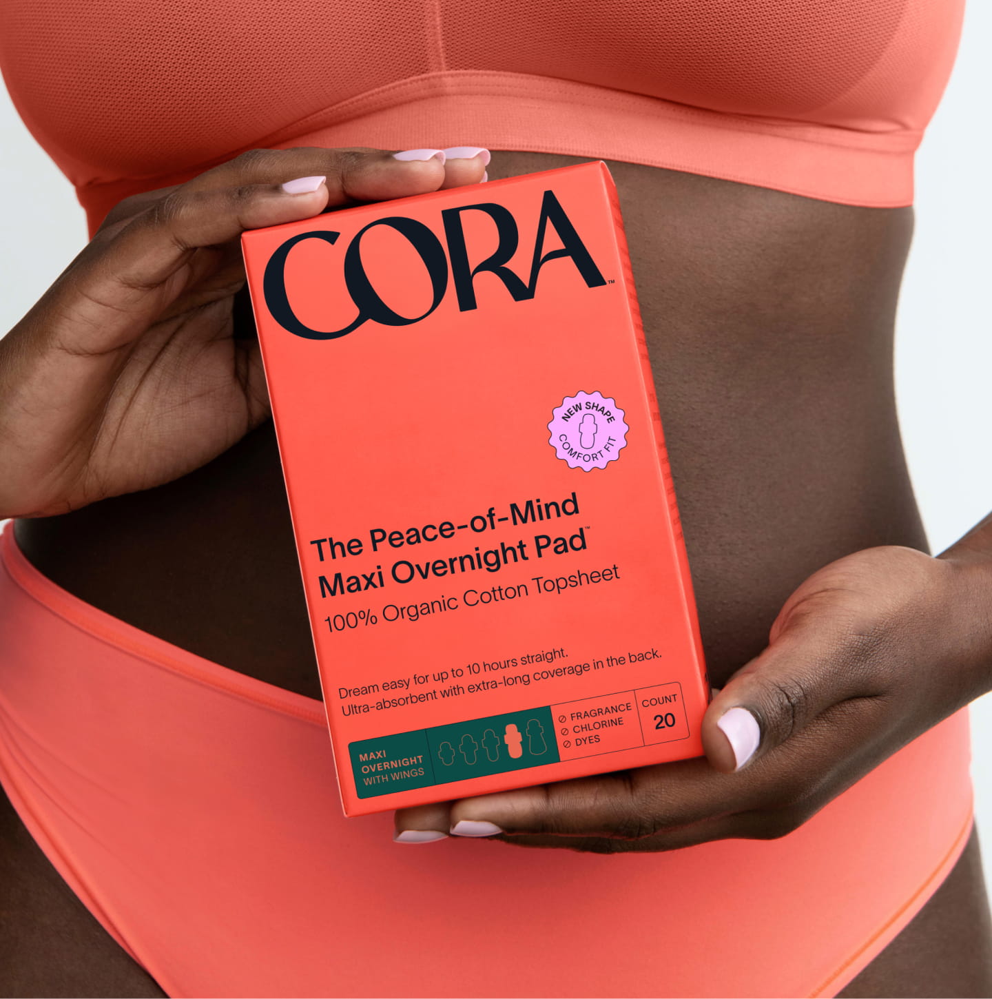 A close up of a person holding a box of maxi pads in front of their stomach