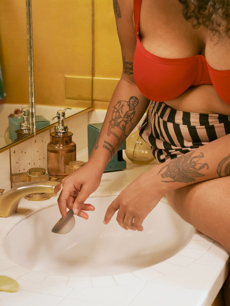 A period disc being washed in the sink