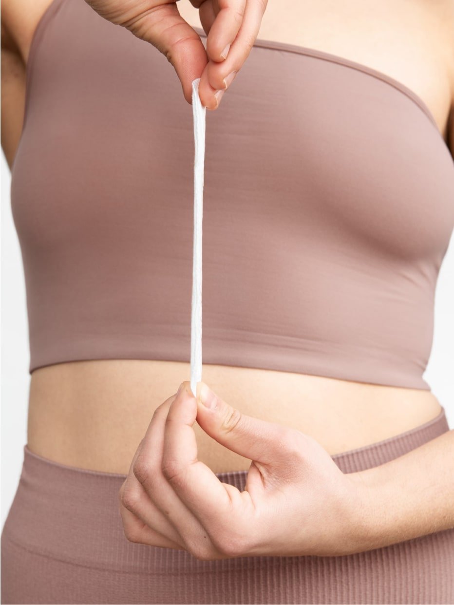 A close up of a person holding a liner lengthwise in front of their chest