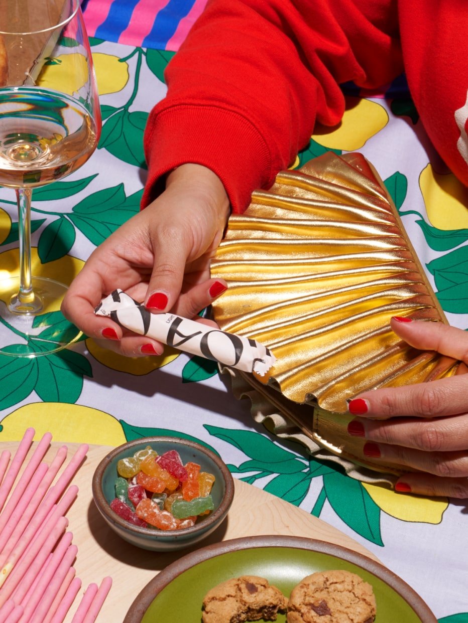 A close up of a hand pulling out a tampon from a bag at a table