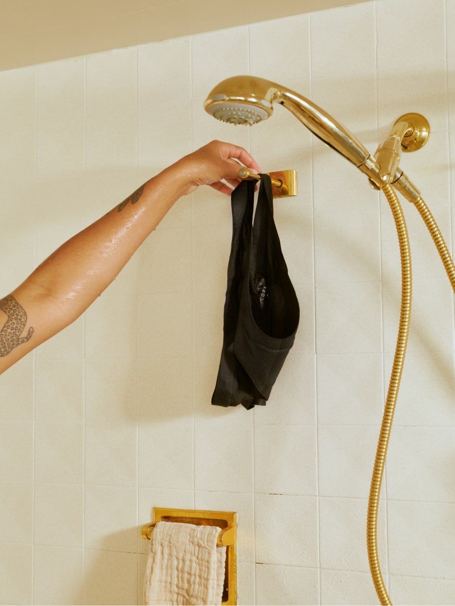 A person rinsing off a pair of Free-to-Flow Period Underwear in the shower