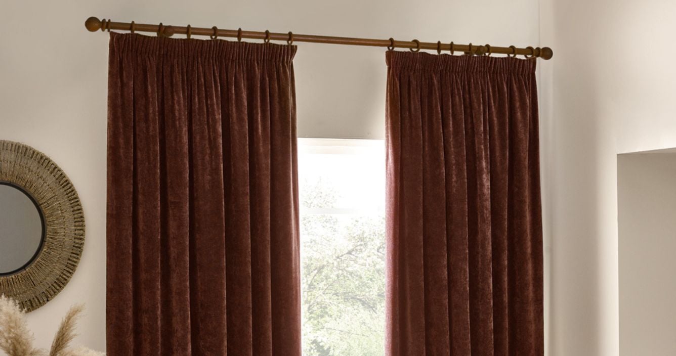 Brown pencil pleat curtains in a heavy chenille fabric hung on a wooden curtain pole.