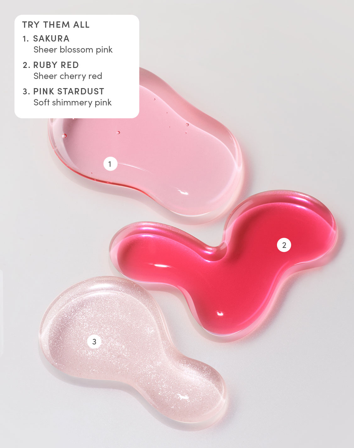 Swatches of Evereden Hydrating Tinted Lip Oil in Sakura sheer blossom pink, Ruby Red sheer cherry red, and Pink Stardust soft shimmery pink.