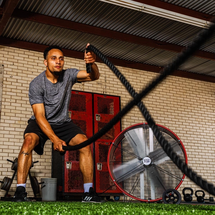 30 in. direct drive drum fan cools a man working out in gym environment