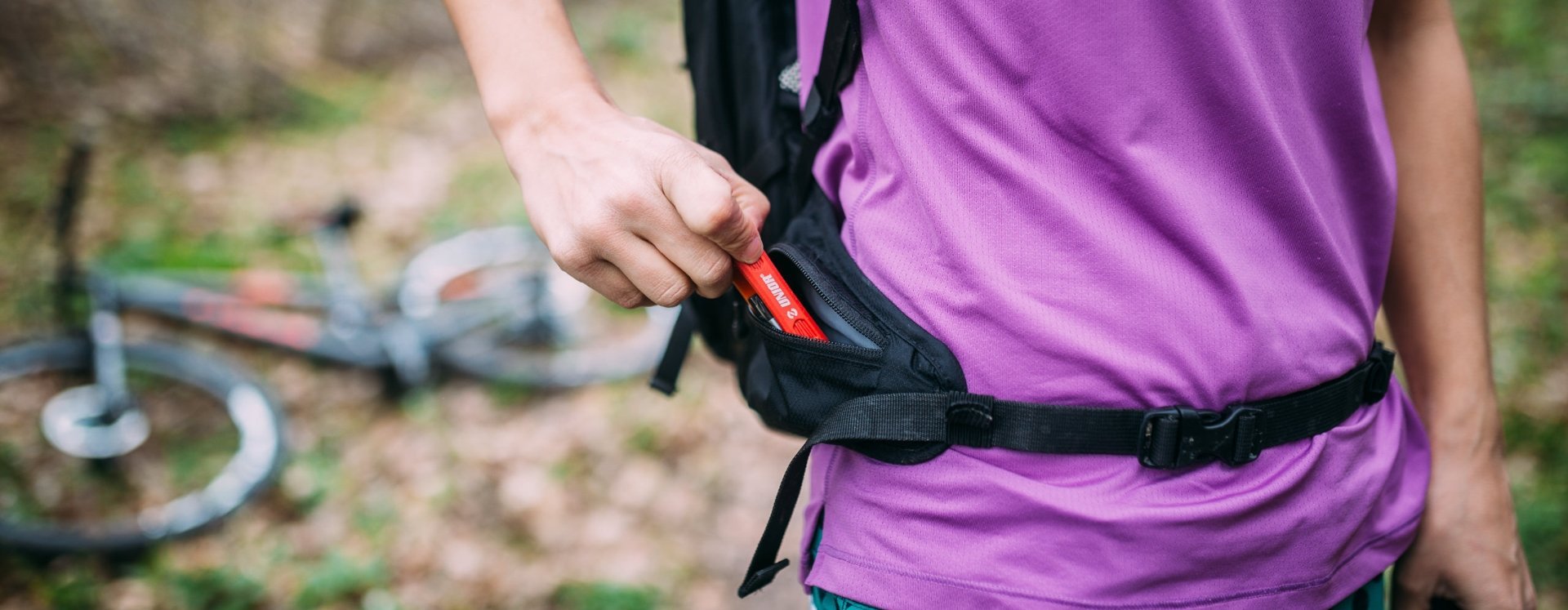 A woman pulls a Unior multitool from her backpack pocket