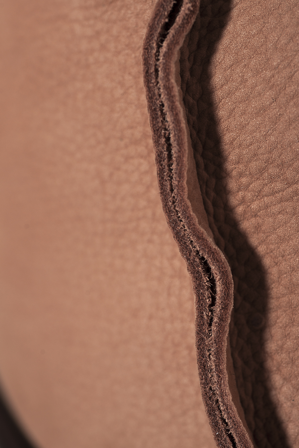 Detail of the raw finished leather that characterises the detail of the Bruxelles armchair. Photo c/o Baxter. 