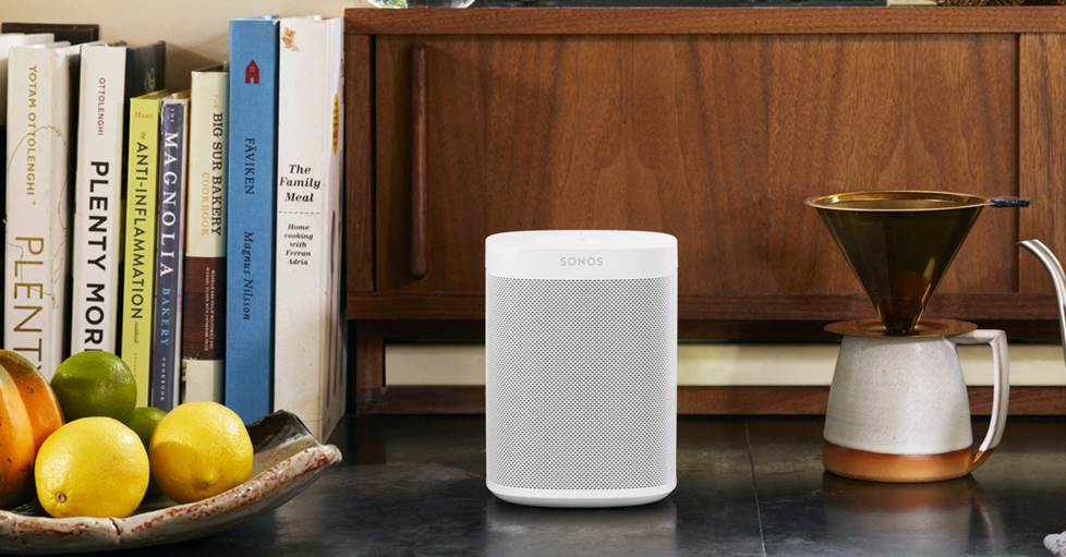 Sonos One next to books on table top