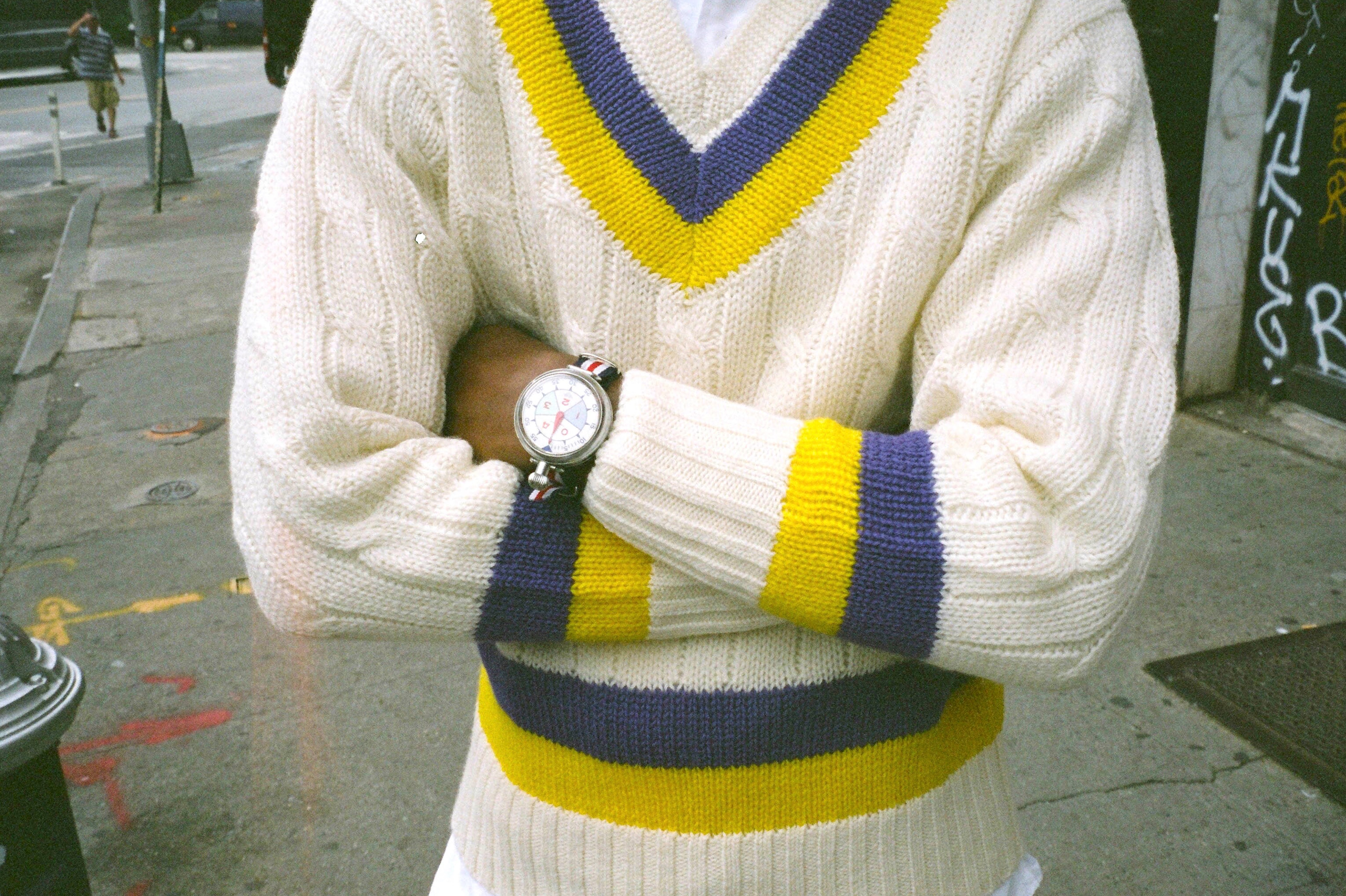Male model wearing the Cream Wool Cricket Sweater in purple and yellow
