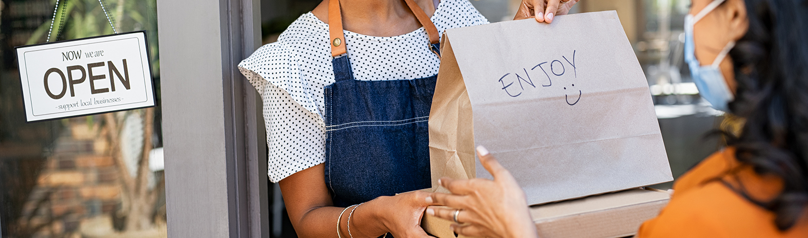 Woman wearing a mask delivering takeout food