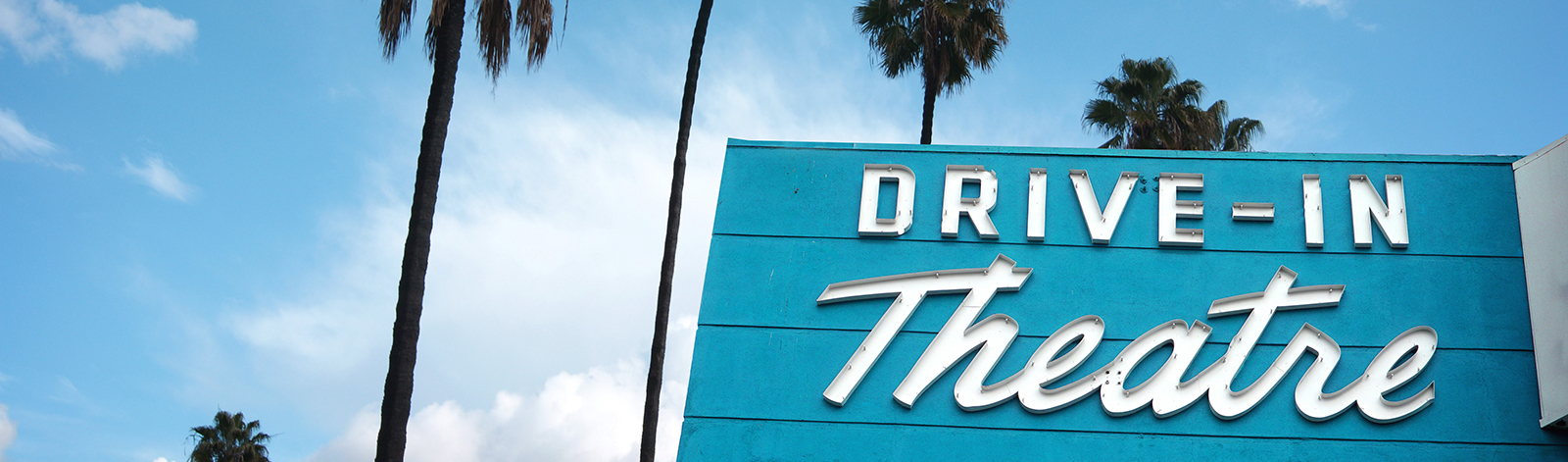 Drive-in theatre sign with palm trees