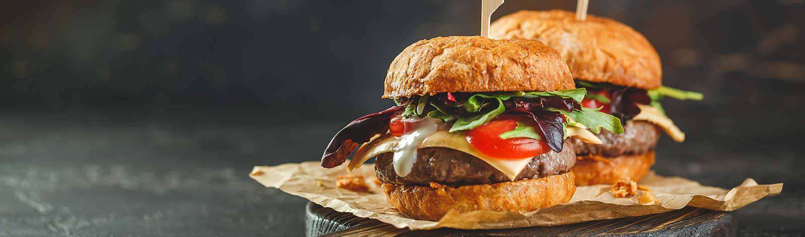 Two hamburgers on a wooden board