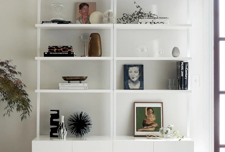 Minimalistic white bookshelf with paintings