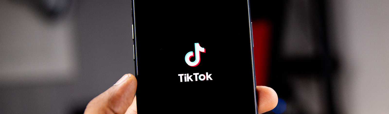 Hand holding smartphone with the TikTok app