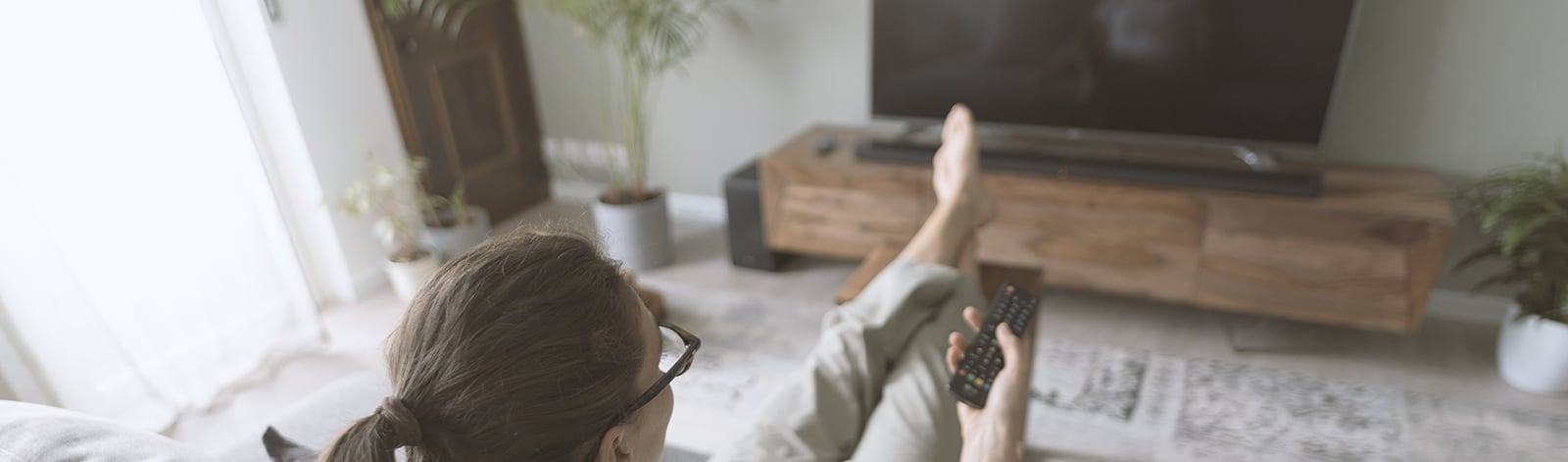 Woman sitting on the sofa and watching TV