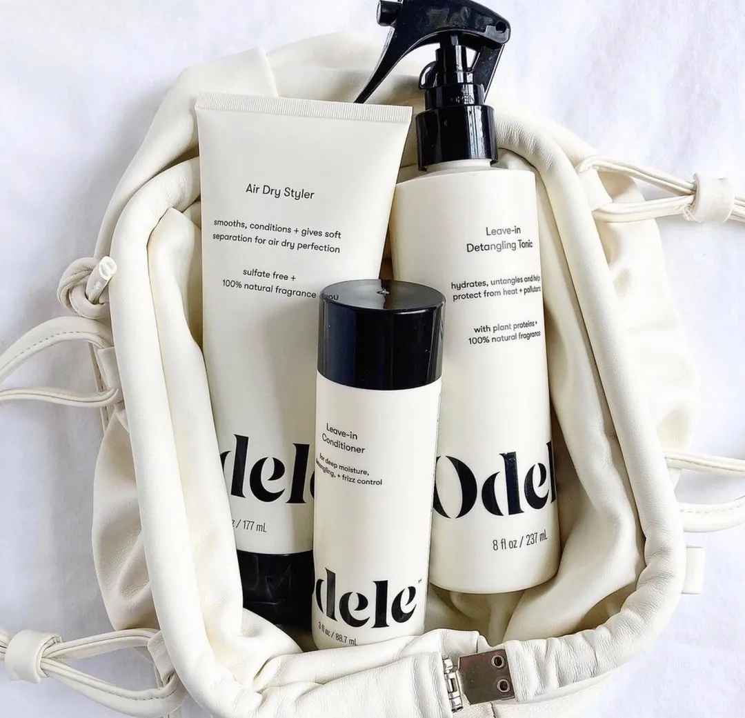 Odele Air Dry Styler and Leave-in Detangling Tonic peeking out of a white bag