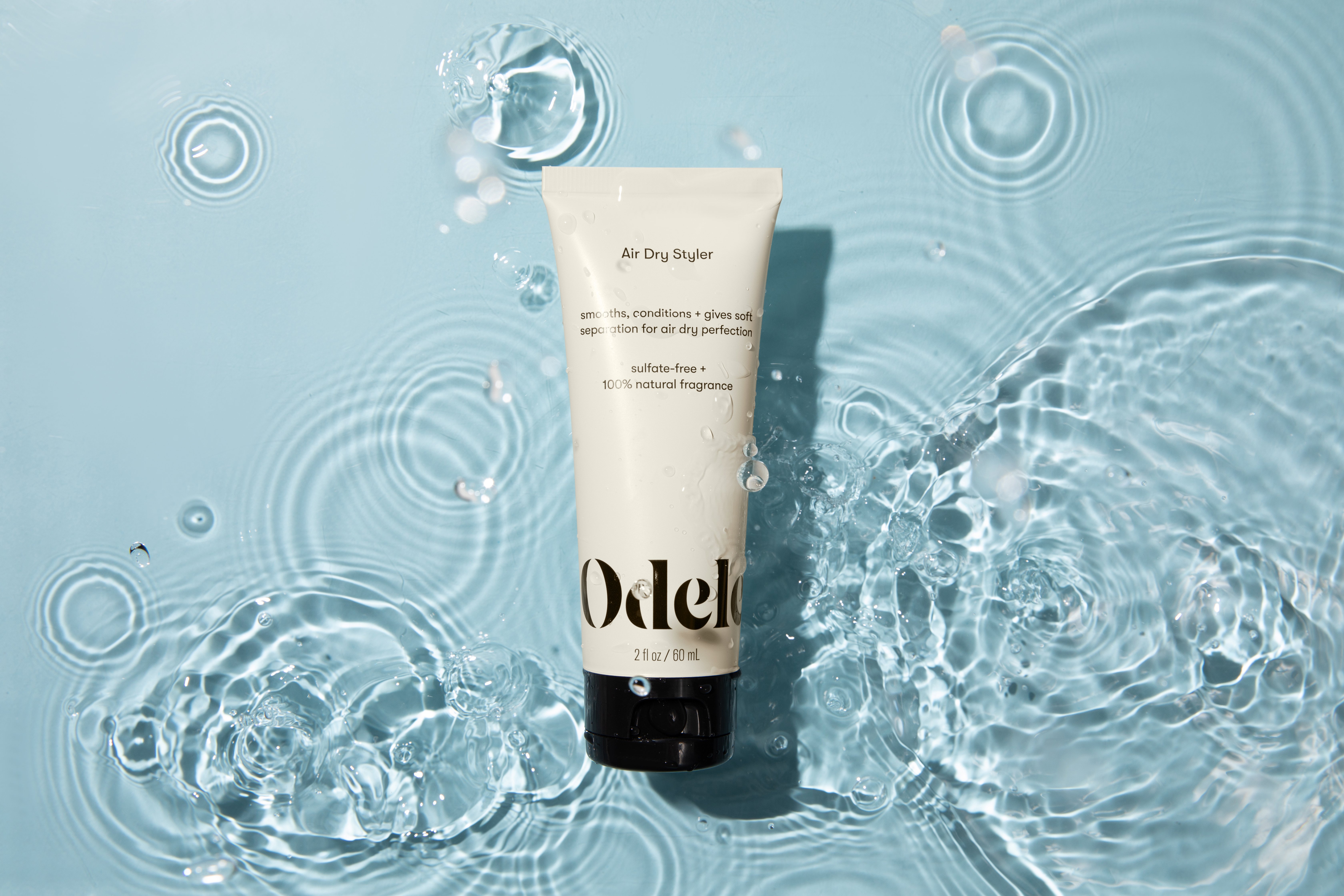 Travel-sized Odele Air Dry Styler floating in water