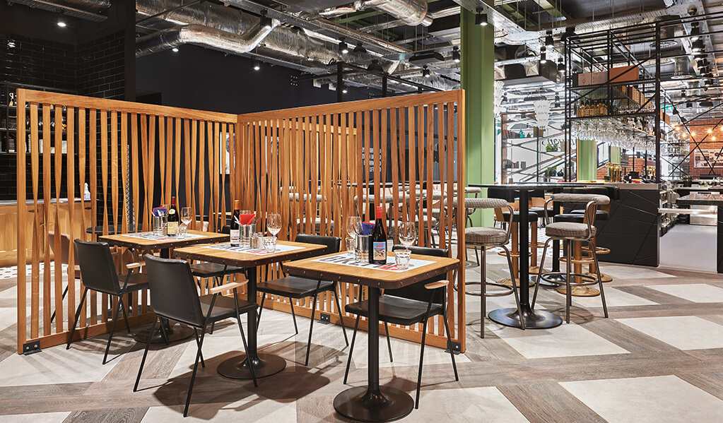 Hotel Brooklyn restaurant with exposed ceiling and slatted wooden divider.
