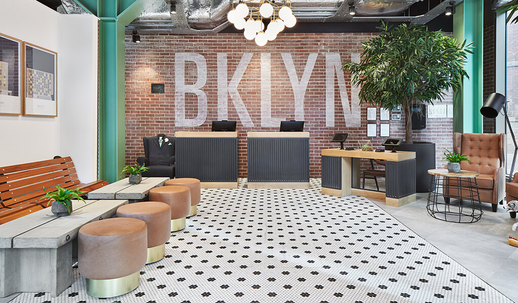 Hotel Brooklyn reception with accessible lower height check-in desk with knee-clearance for wheelchair users. 
