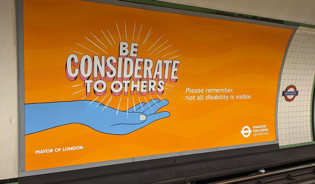 London Underground orange signage on wall reading 'Be considerate to others'. 
