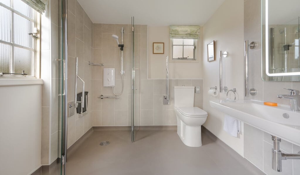 Neutral tone bathroom with chrome detailing throughout showcasing the bifold shower screen and chrome detailed shower. 
