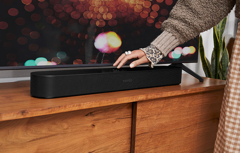 Hand touching Sonos Beam Gen 2 Black on table top