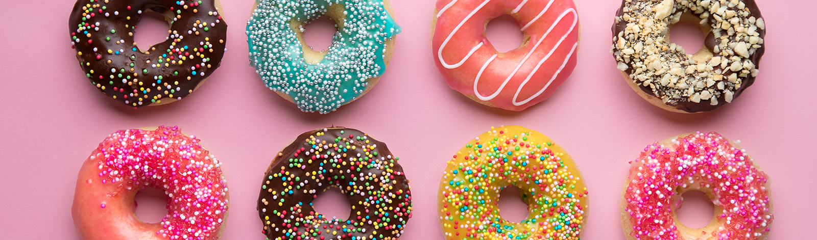 Variety of donuts on a pink background