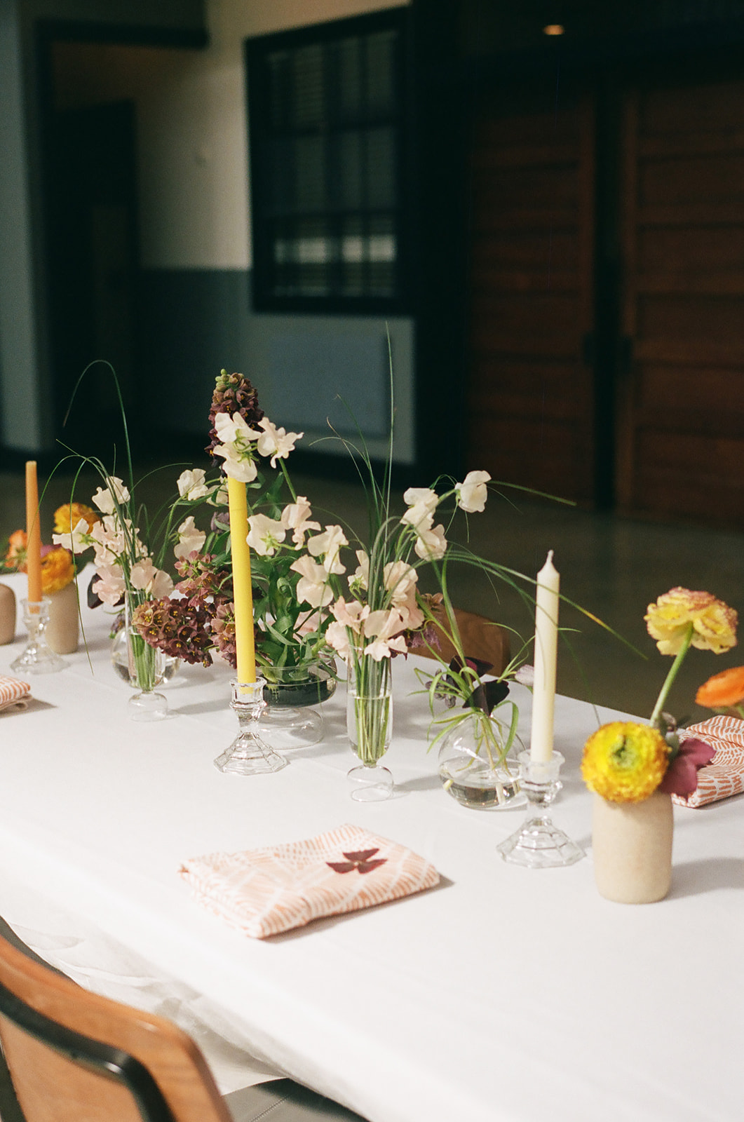 Florals displayed in glass vessels.