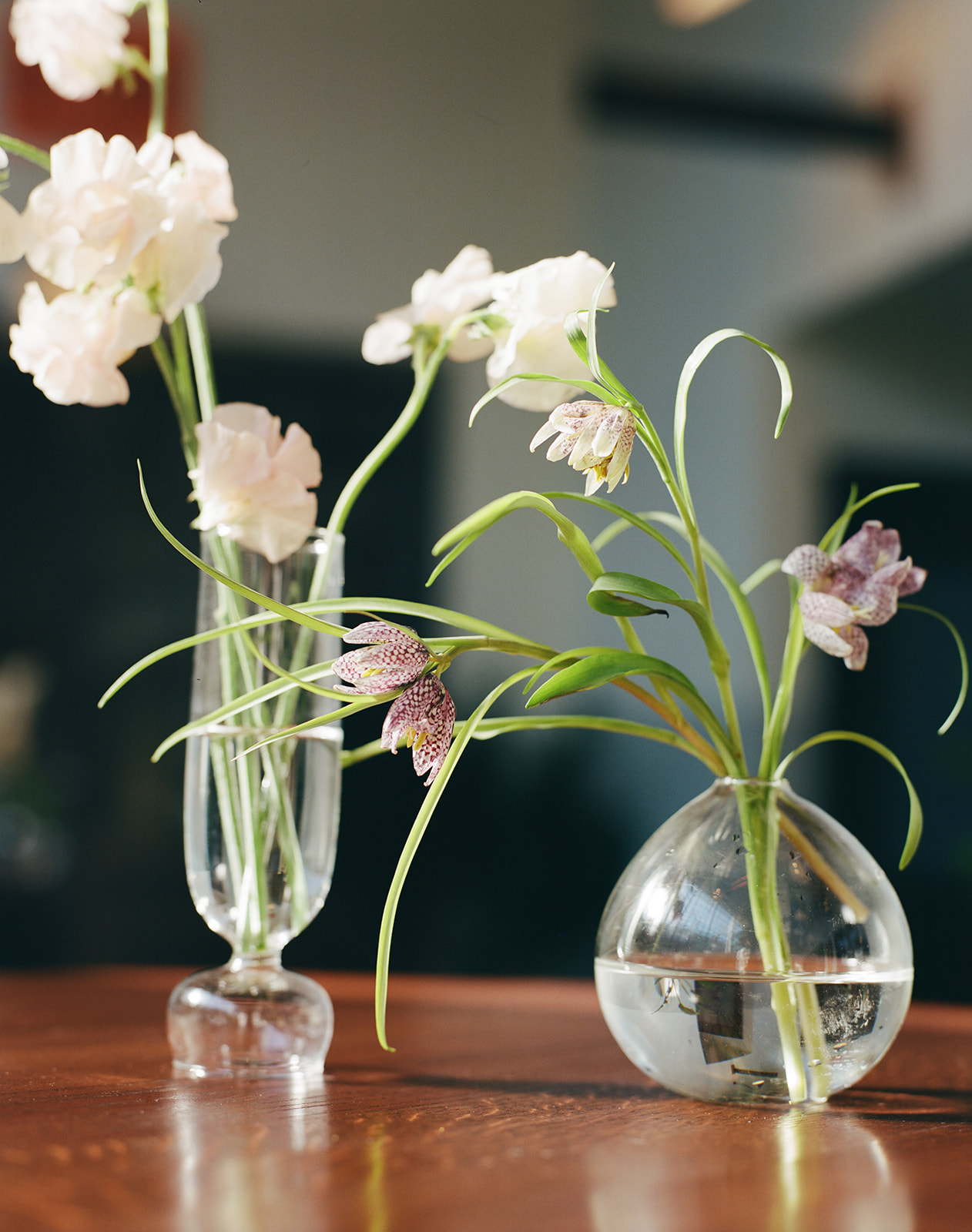 Florals displayed in glass vessels.
