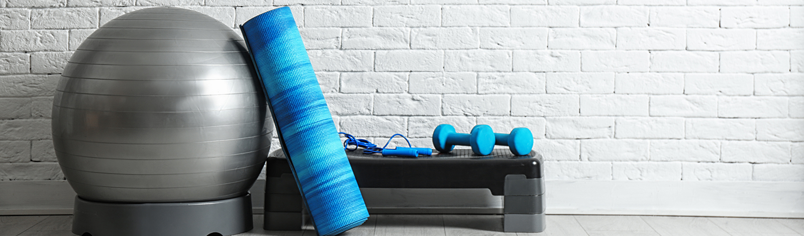 Set of fitness equipment on the floor near a white brick wall