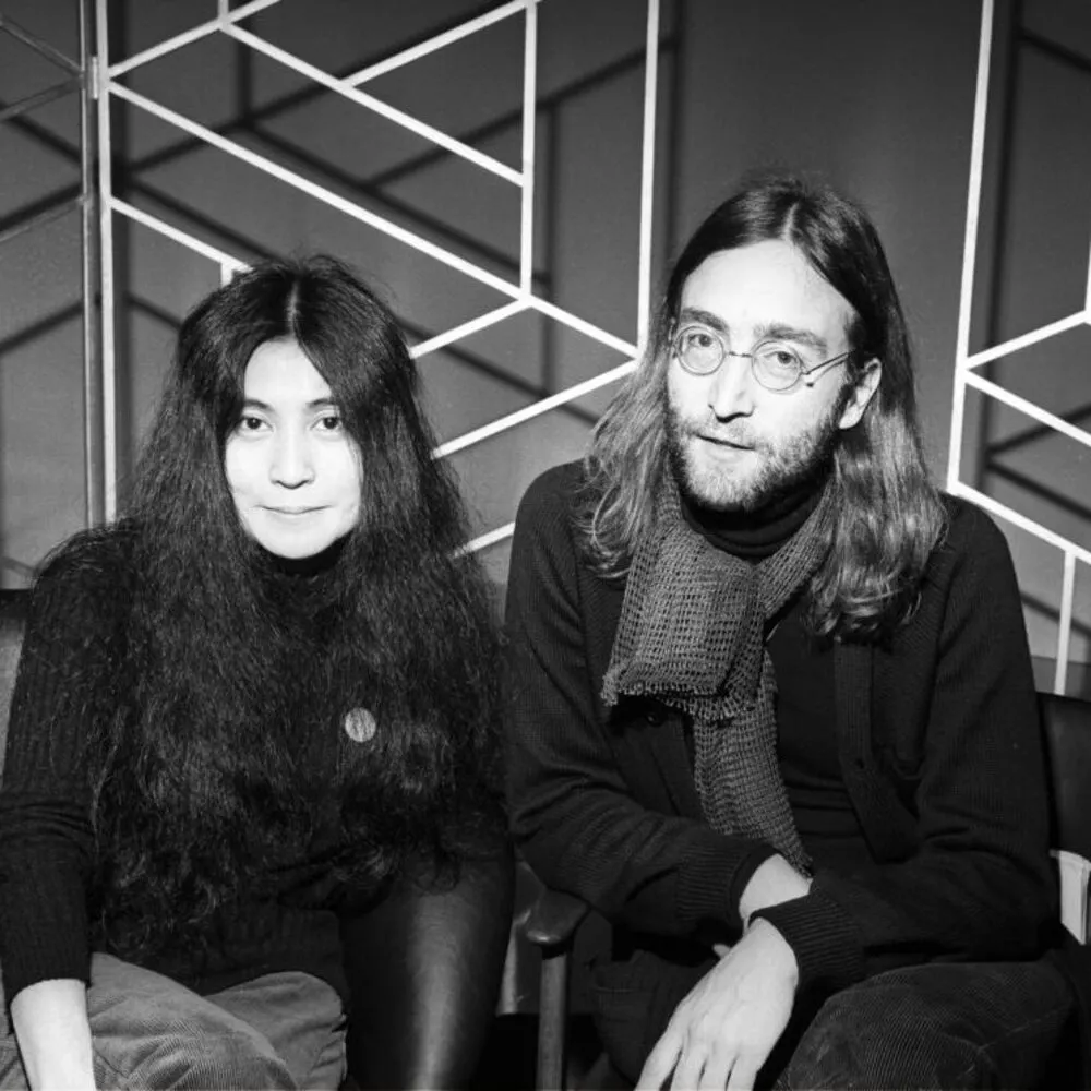 Black-and-white image of John Lennon and Yoko Ono with long, unstyled natural hair 