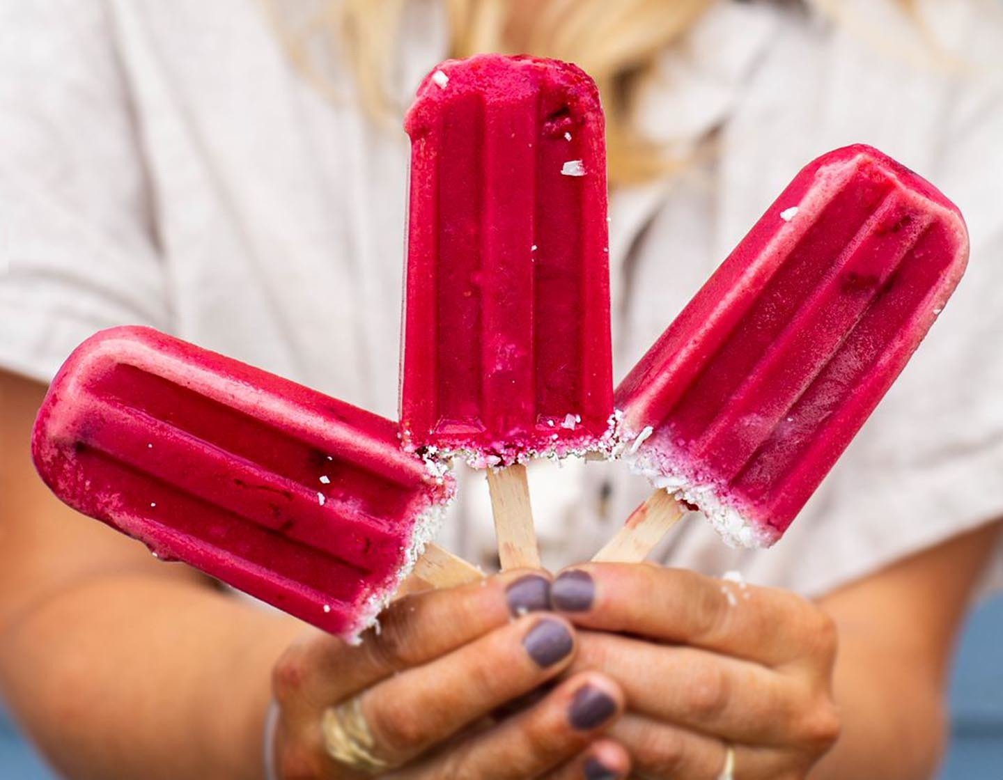 Holding three Raspberry Coconut Tea Popsicles