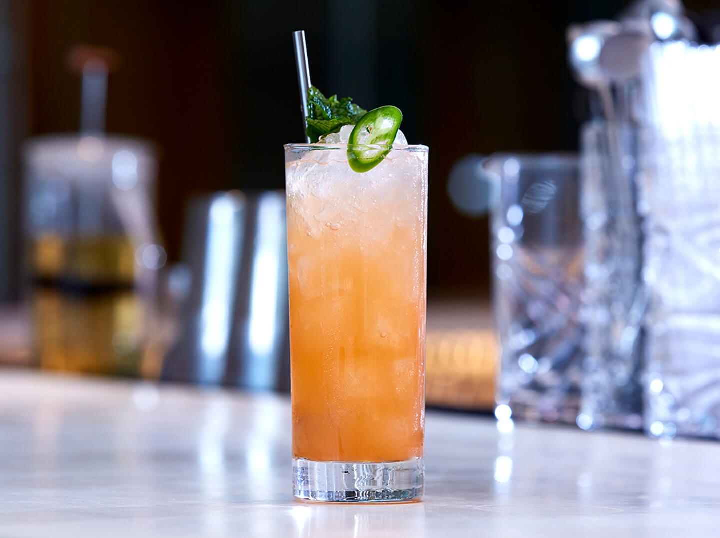 Orchid Vanilla Collins cocktail in a tall glass on a bar