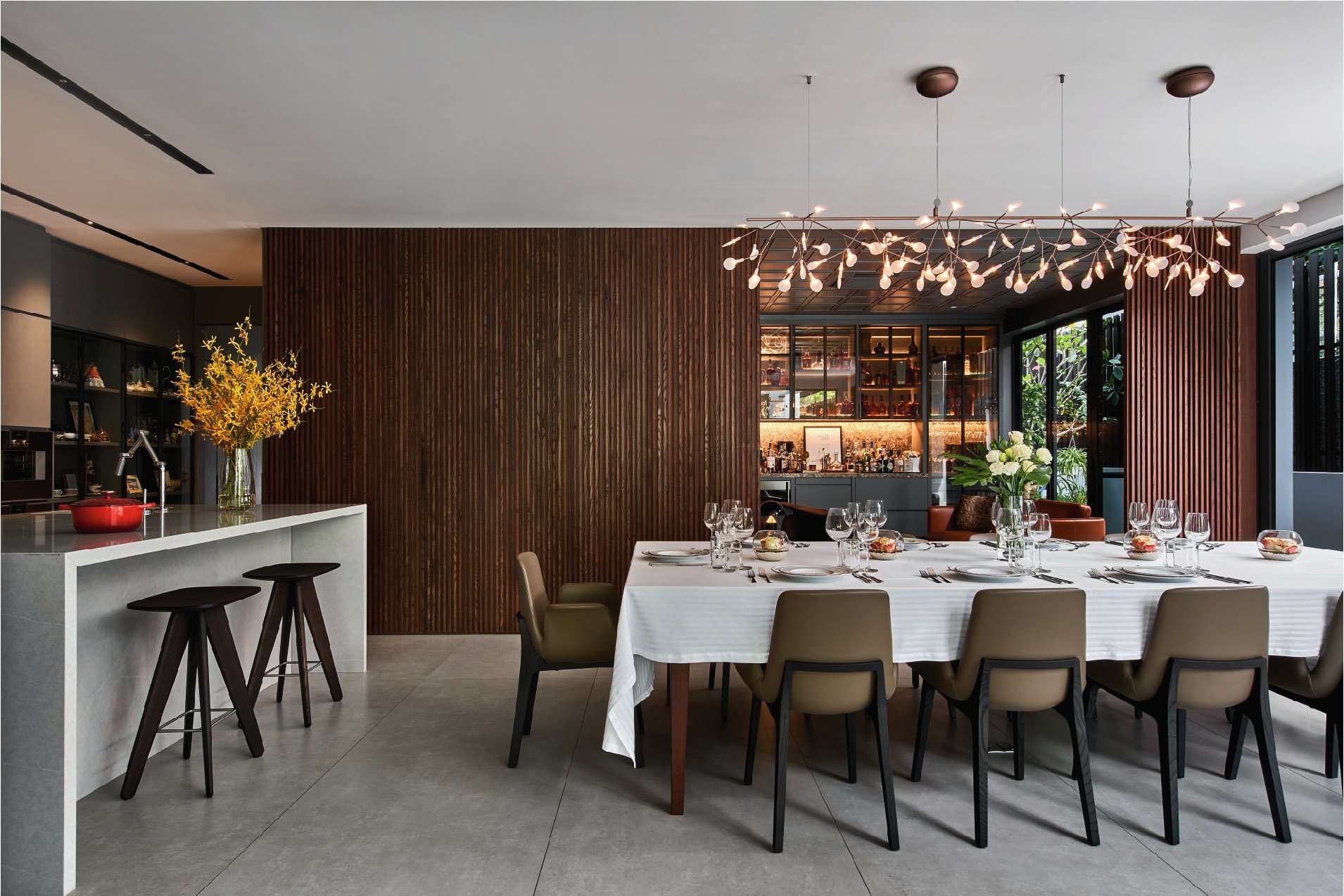 The interior's dark wood panelling is complemented by Moooi's delicate, floating Heracleum II pendant above the Poliform dining table and chairs.