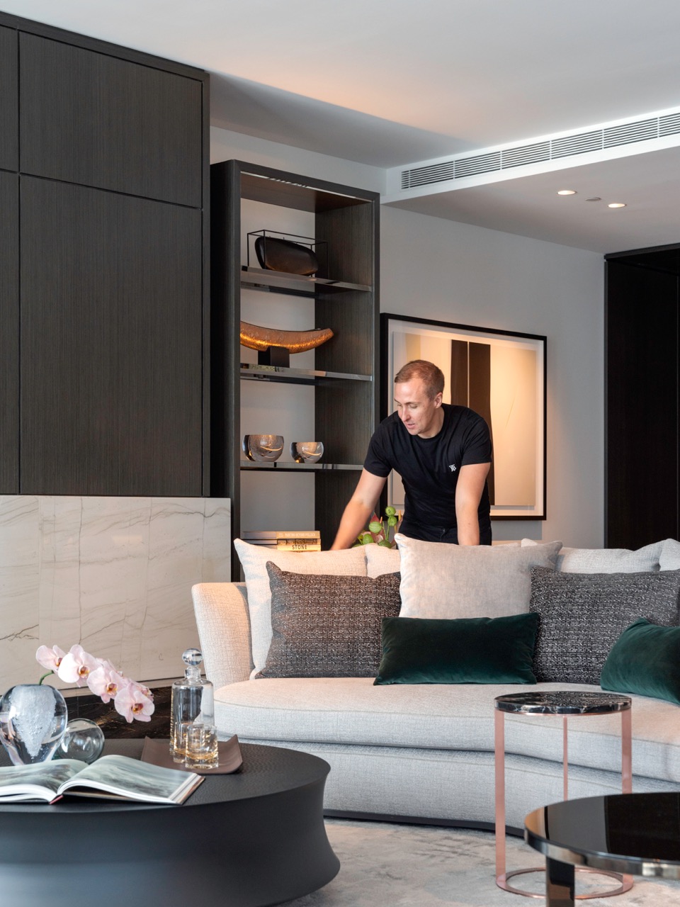 David Hartikainen inside the living space of the Crown Residences display suite, with the Maxalto Apollo Sofa and B&B Italia Frank Side Tables. Photo © Justin Alexander. 