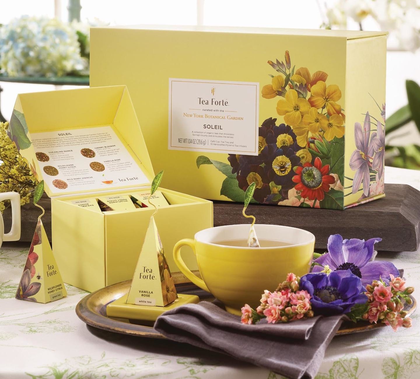 Soleil Gift Set box and mini petite box opened with a yellow cafe cup steeping tea and flowers