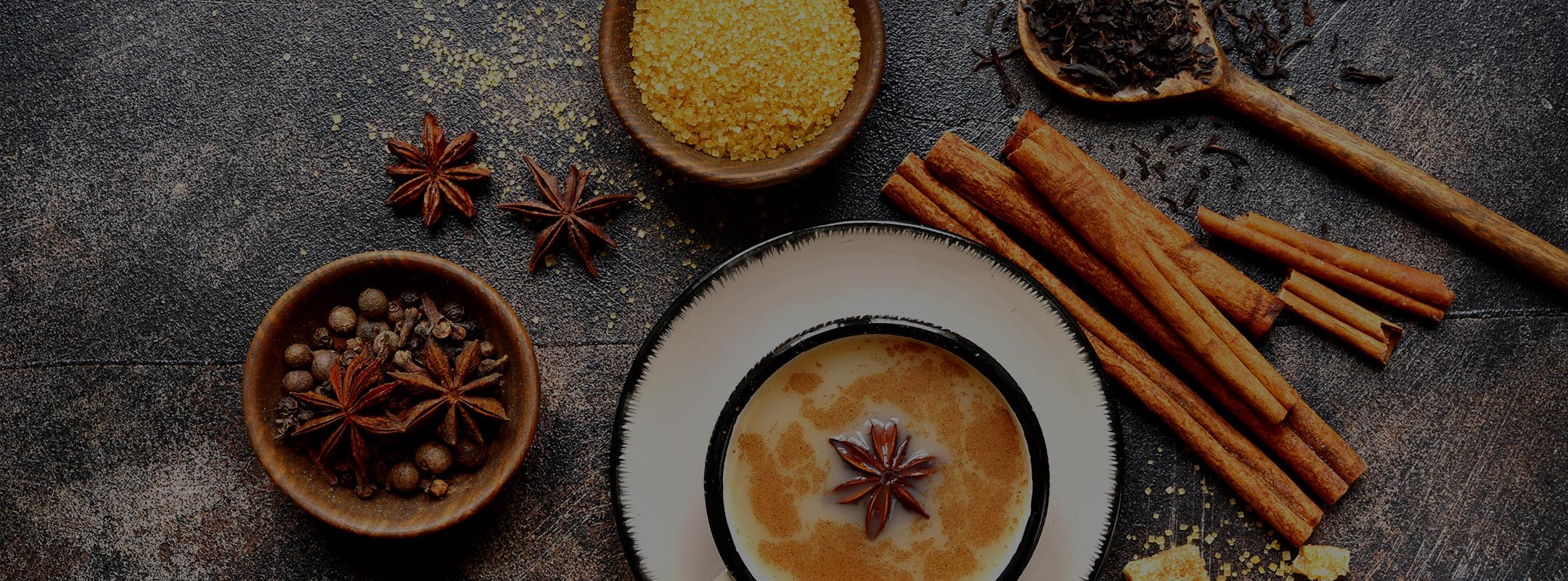 Chai latte from above with spices and an anise seed on the top of the latte foam