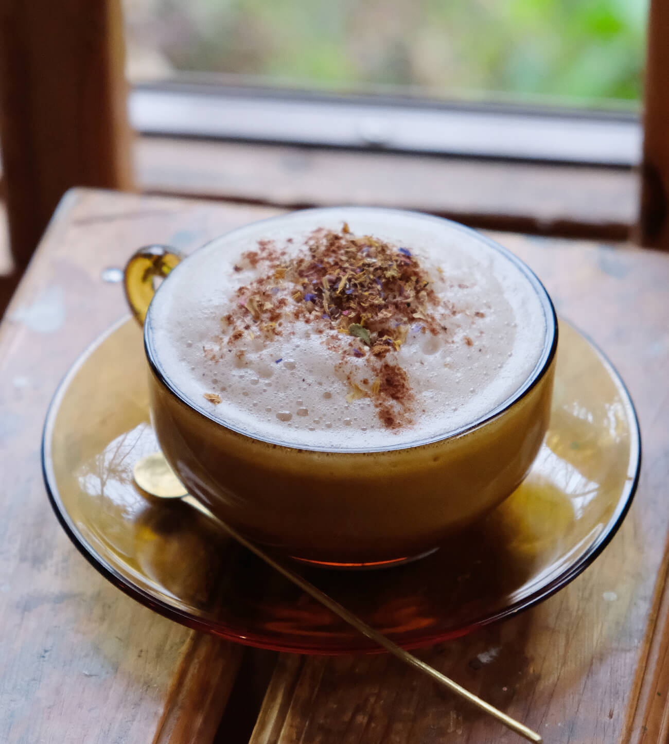 Chai Latte with a head of milk foam topped with a dash of cinnamon