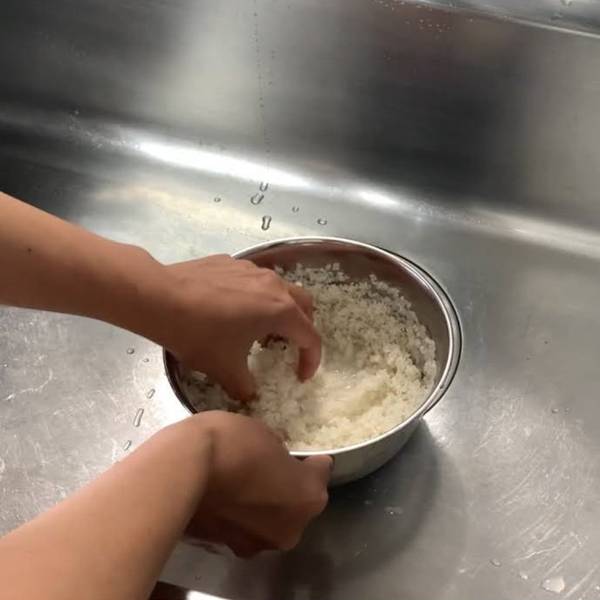 Mixing Water Around to Remove Dust From Rice 
