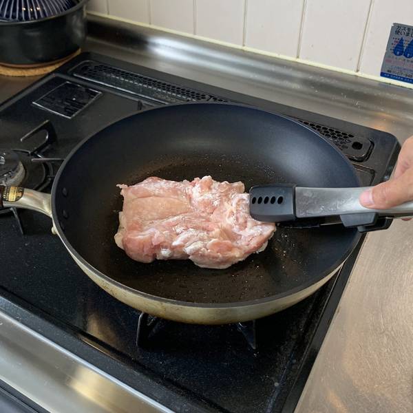 Placing the chicken in the pan skin-side down 