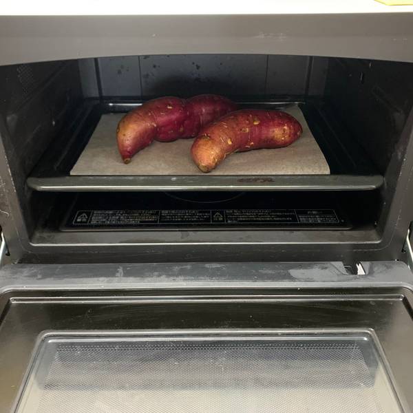 Placing the satsumaimo in the oven for baking