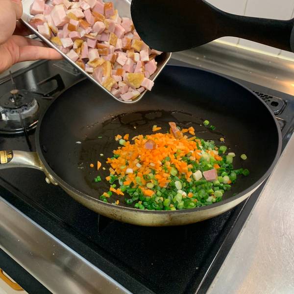 Adding the vegetables and bacon to the fry pan